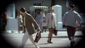 Truman traversant la route, suivi par les caméras